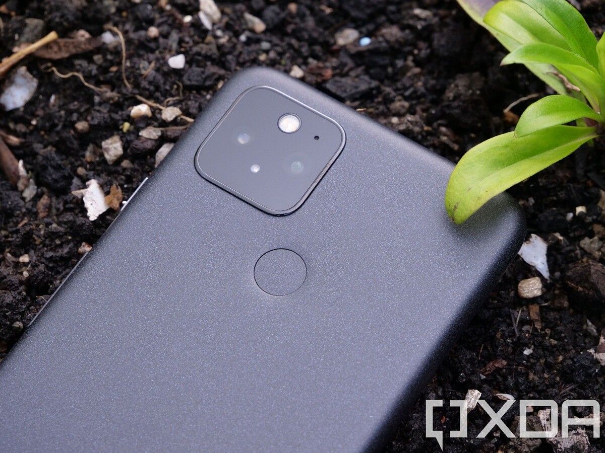 Google Pixel 5 lying in soil bed showing the fingerprint sensor and the camera module