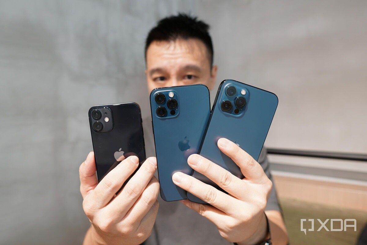 Holding the iPhone 12 Pro Max, iPhone 12 Pro and iPhone 12 Mini.