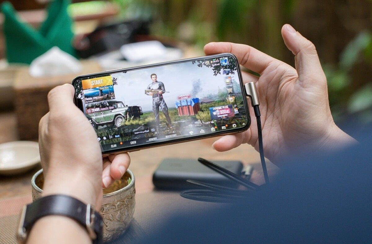 person playing pubg mobile outside by Screen Post