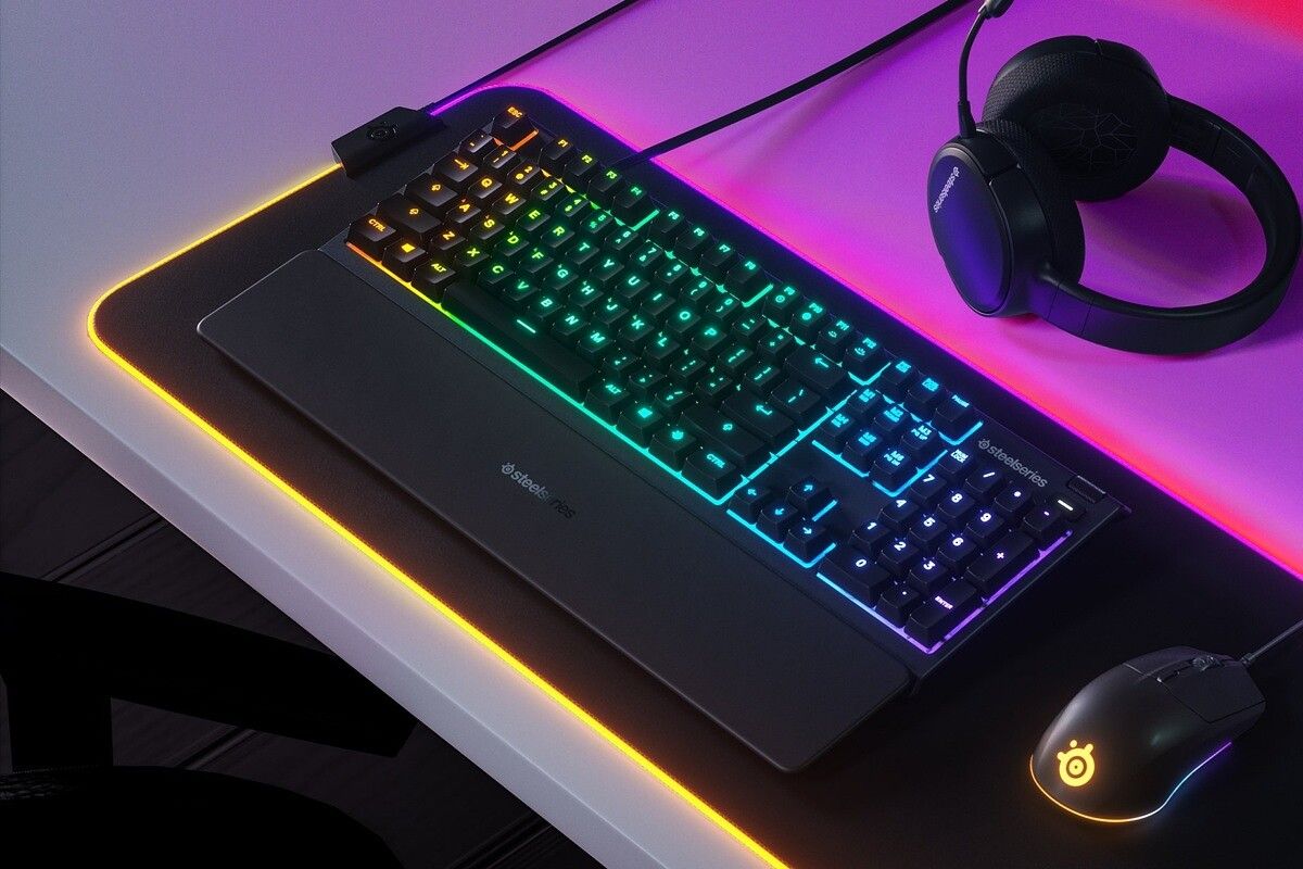 steelseries apex 3 on desk with gaming accessories in rgb lighting