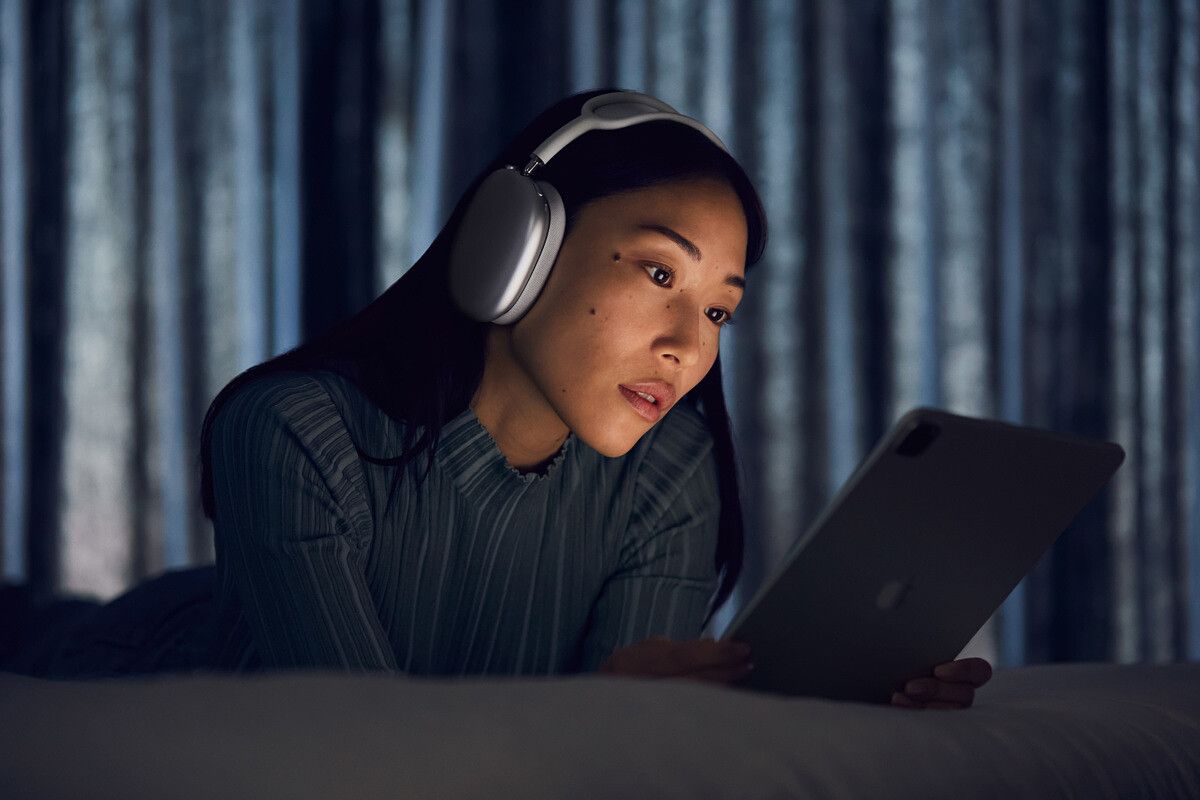 Woman wearing Apple AirPods Max reading off a screen