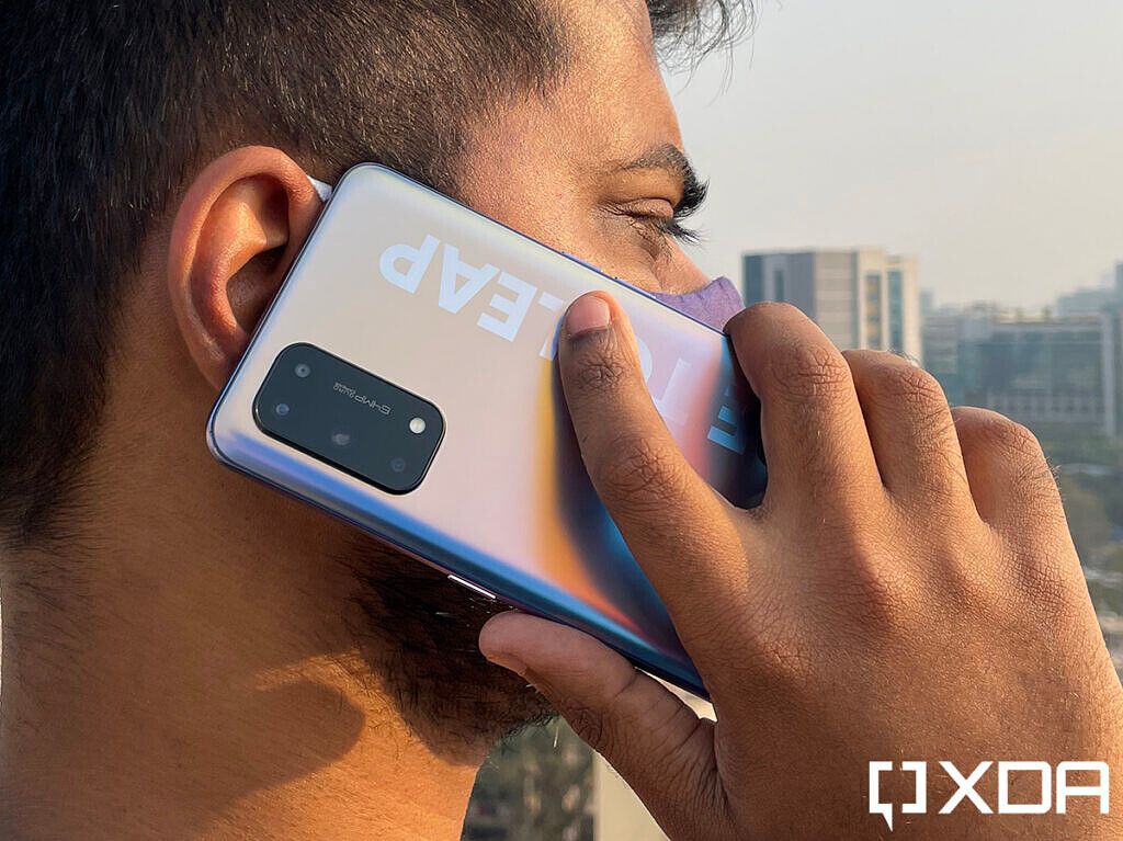 Person holding Realme X7 Pro in hand on a phone call
