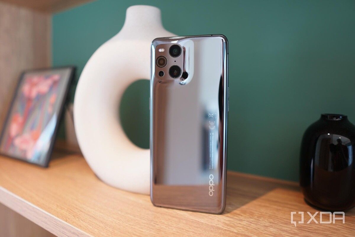 OPPO Find X3 Pro on a shelf with white vase and picture frame