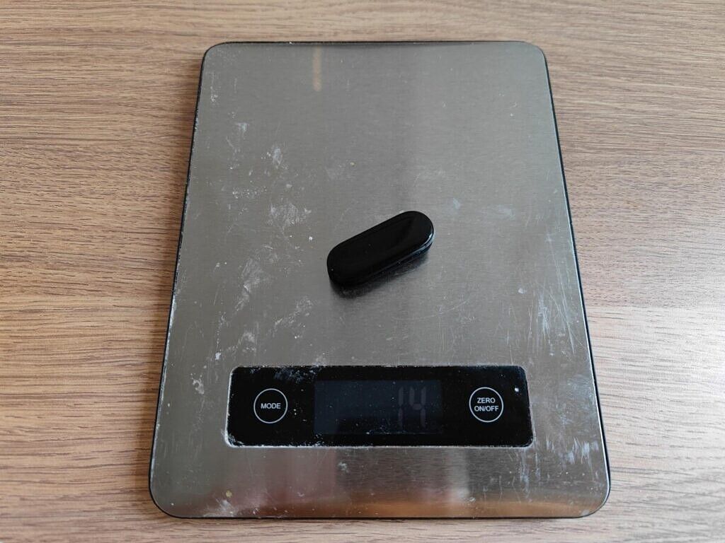 The Xiaomi Mi Band 6 on a food scale showing its weight.