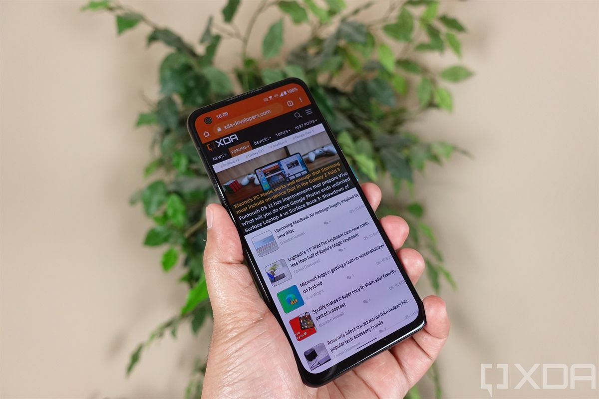 Holding up the ASUS ZenFone 8 with a plant in the background