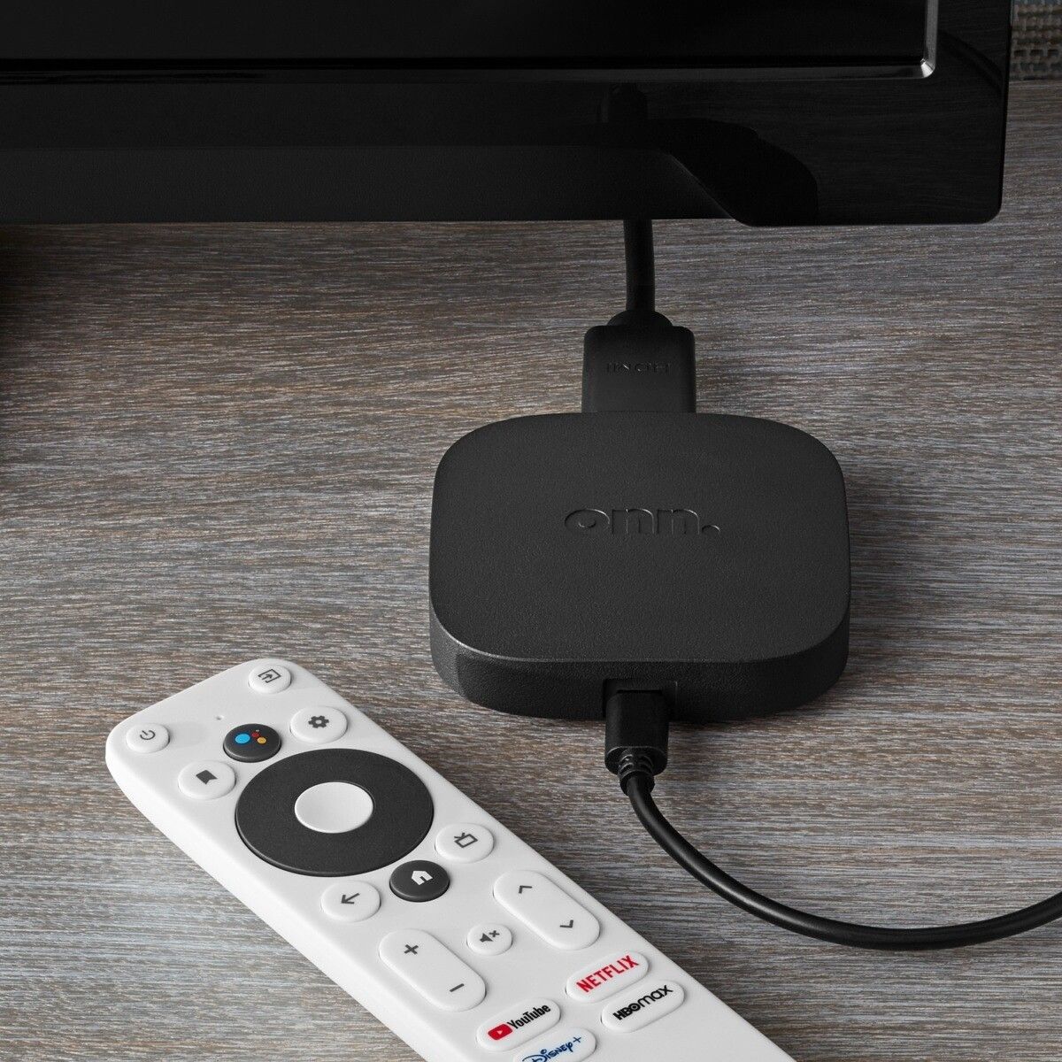 A lifestyle shot of the Walmart Onn 4K set-top box with the remote.
