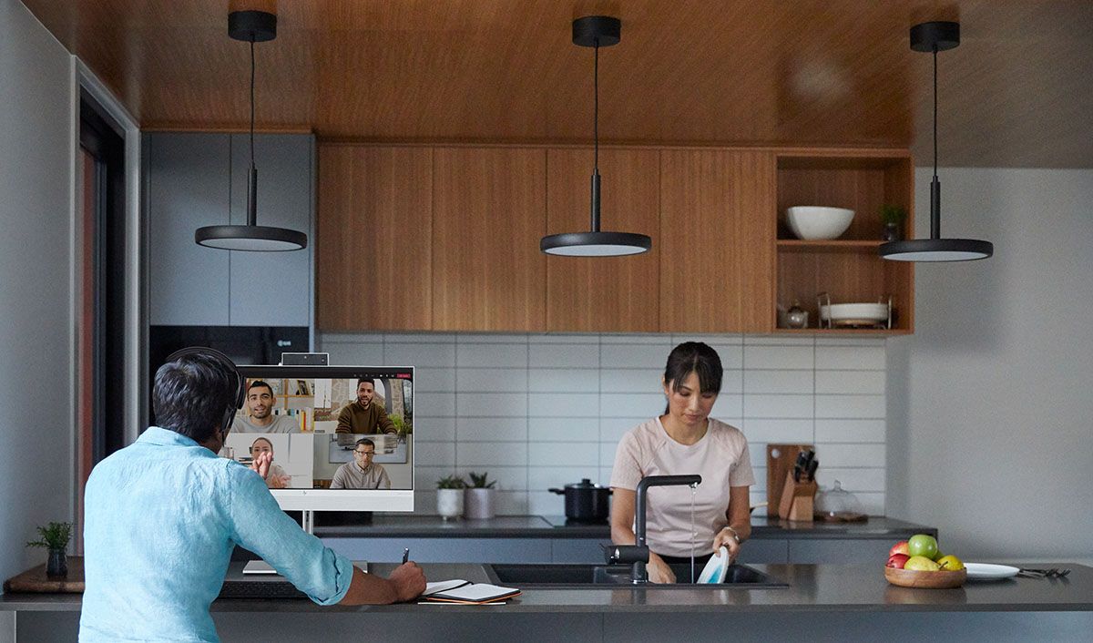 HP EliteOne 800 G8 All-in-One on kitchen counter next to woman washing dishes