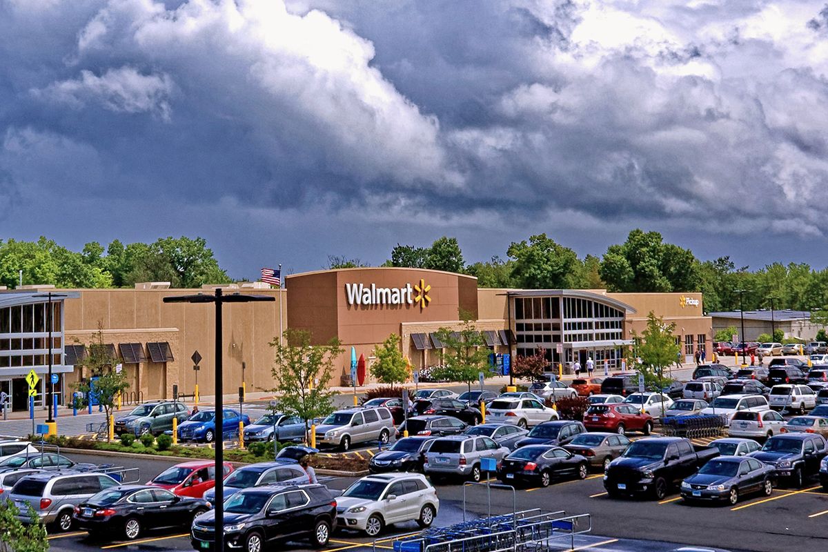 Image showing a Walmart store front with parking lot infront and heavy cloud cover in the background