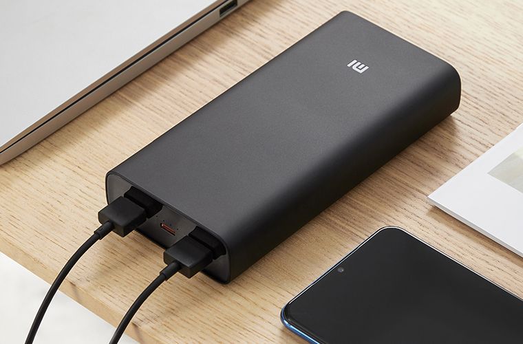Mi Hyper Sonic power bank sitting on a table with two USB cables plugged