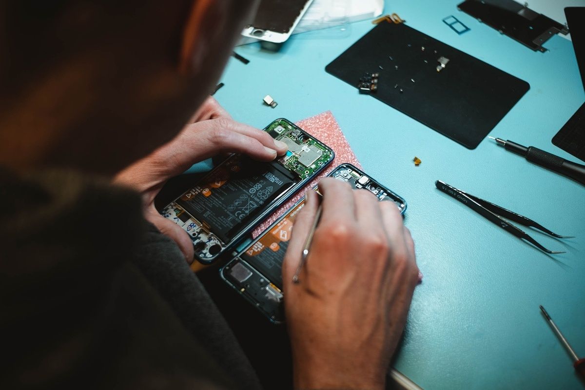 A person trying to repair a smartphone