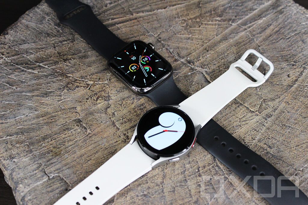 Apple Watch and Samsung Galaxy Watch 4 with bands crossed