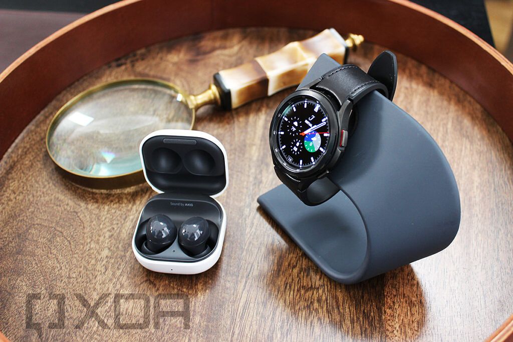 Samsung Galaxy Buds 2 and Galaxy Watch 4 with magnifying glass in background