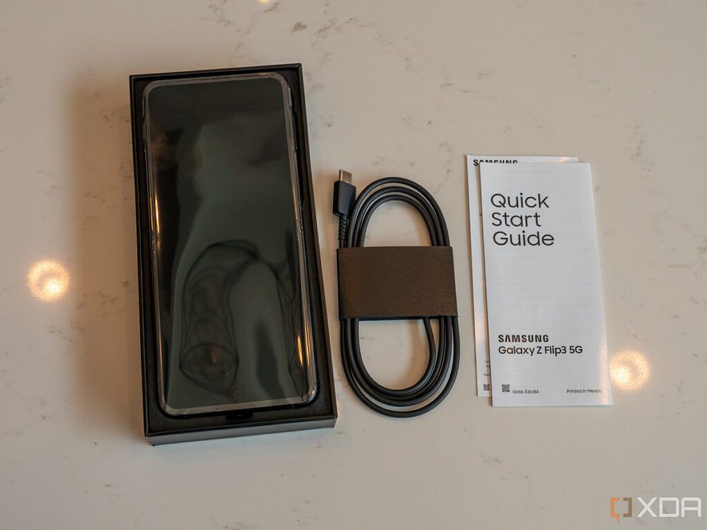 Galaxy Z Flip 3 unboxed with charger and quick start guide to the side