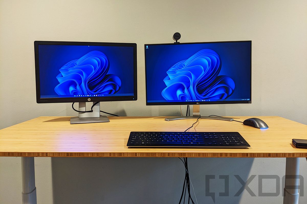 Wooden desk with keyboard and two monitors on top