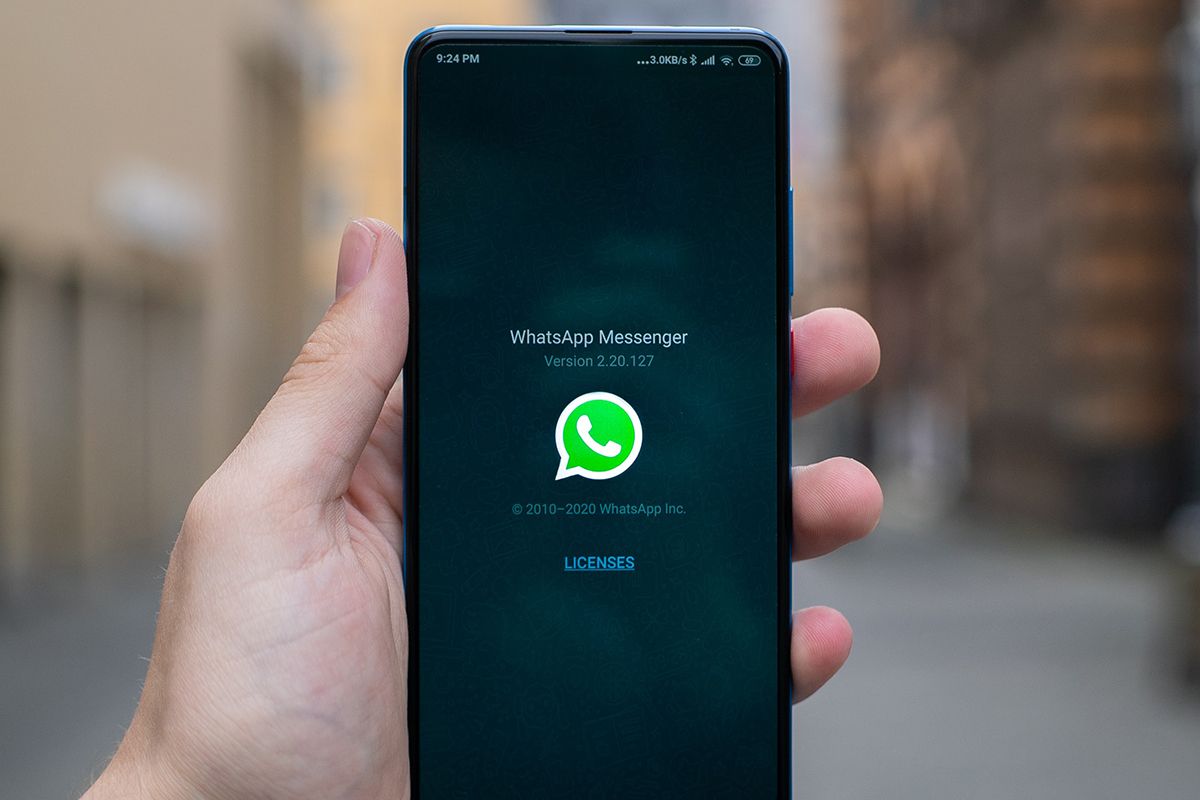 WhatsApp messenger splash screen on phone in hand