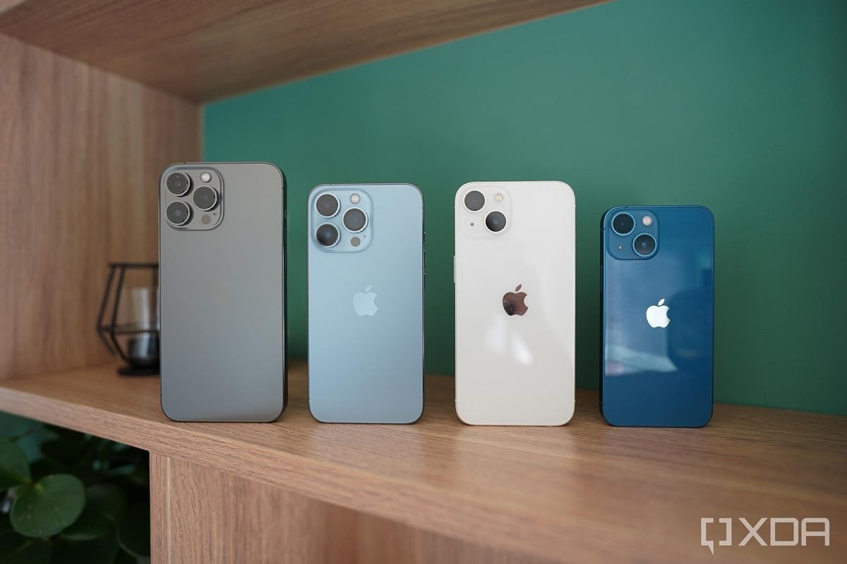 All four iPhone 13s on a woooden shelf.