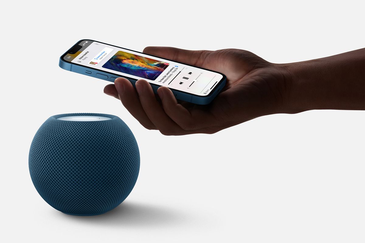 Apple HomePod Mini in blue with an iPhone next to it