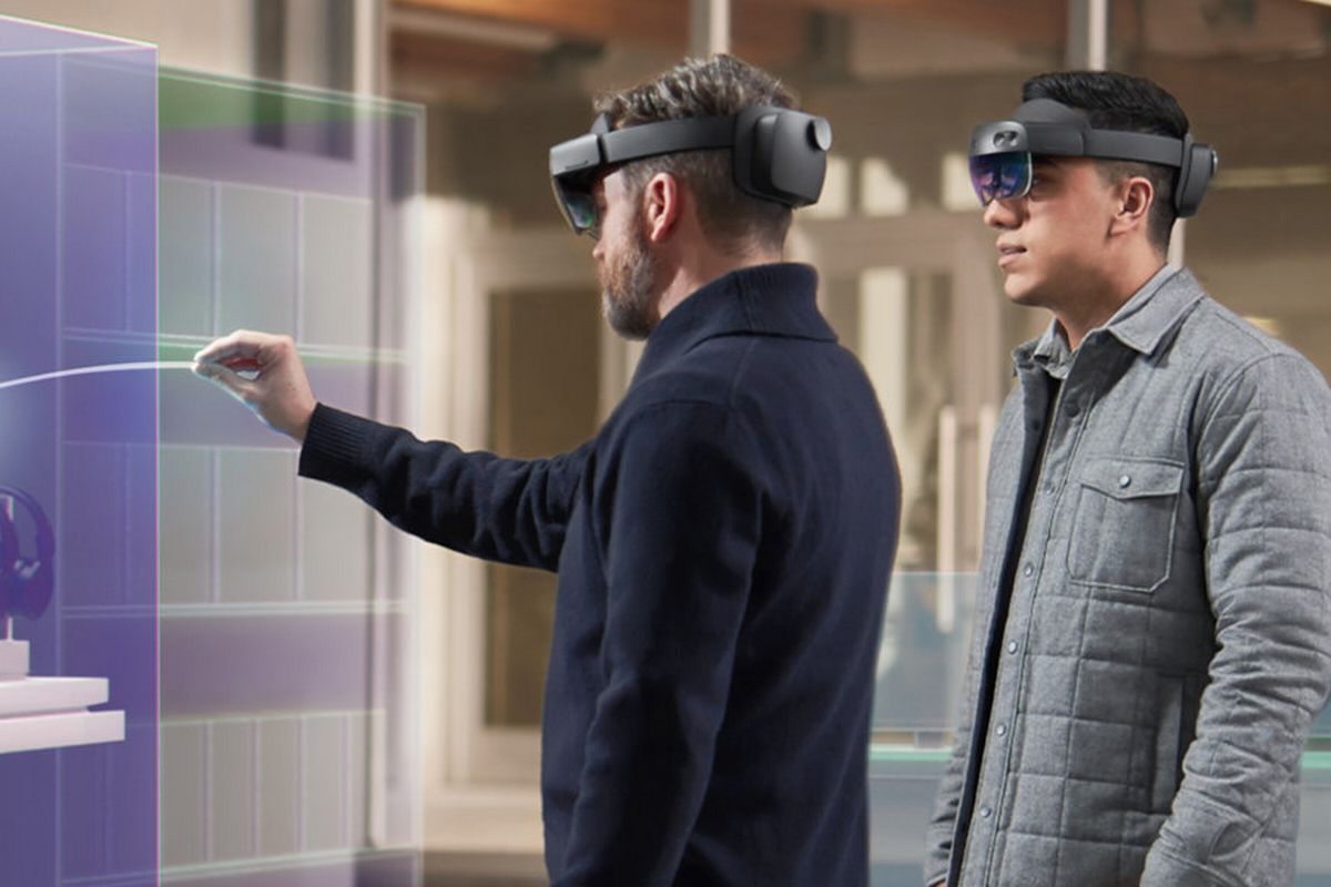 Two people wearing HoloLens 2 heaadsets and interacting with augmented reality apps