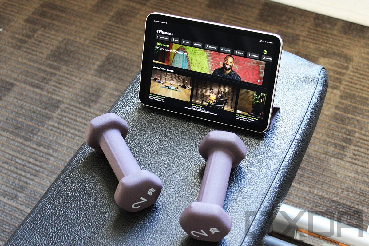 iPad mini avec haltères violets et Apple Fitness+