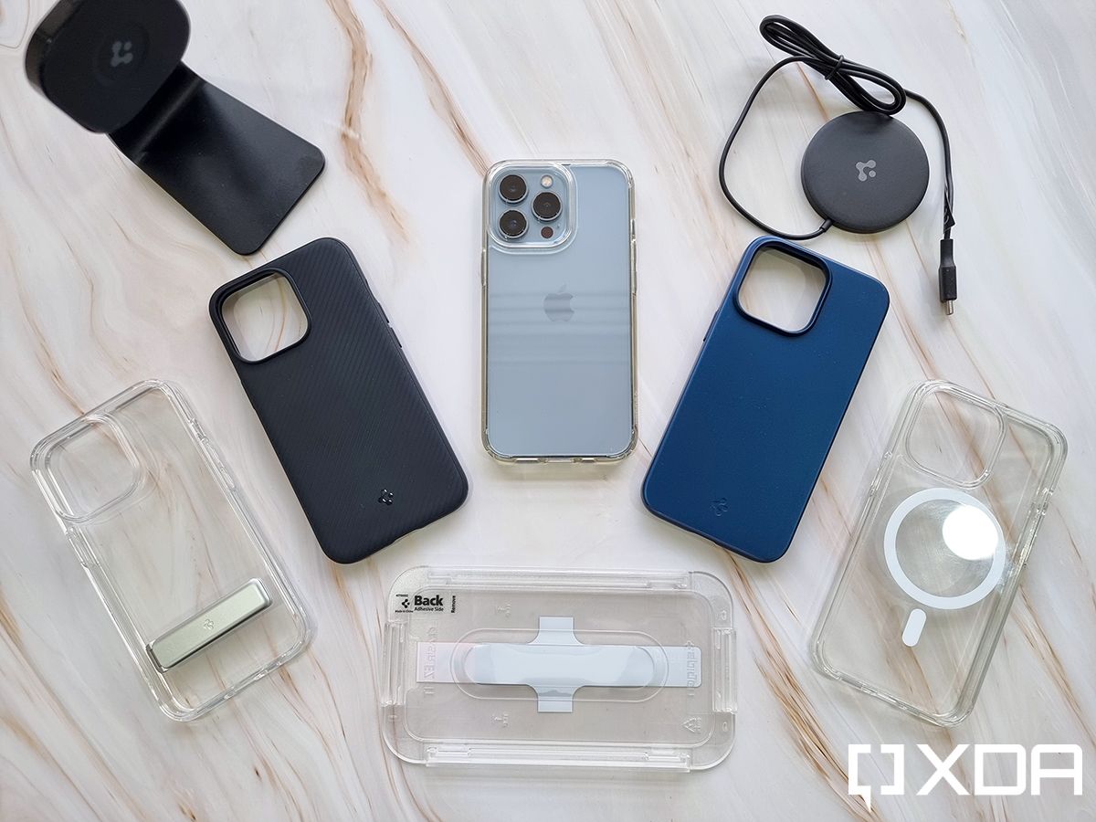 Spigen Cases for Apple iPhone 13 Pro laid out on a flatlay background, along with some accessories