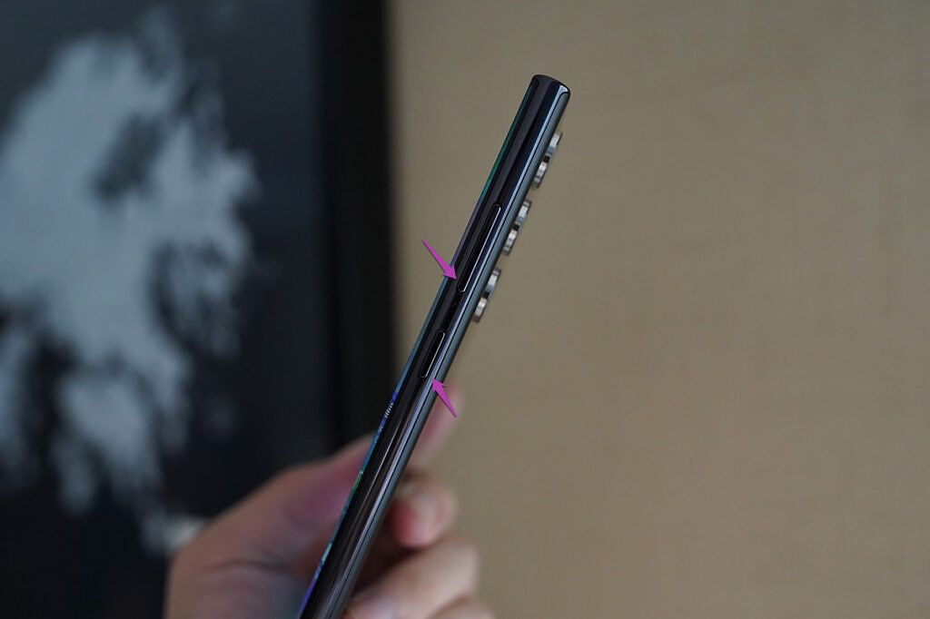Side view of the Galaxy S22 Ultra with arrows pointing at side key and volume down button
