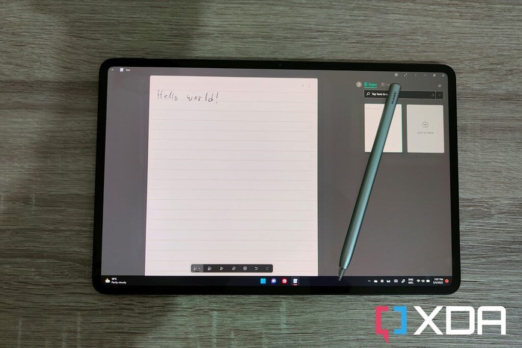 Overhead view of the HUAWEI MateBook E with the M-Pencil resting on the display and handwritten text reading &quot;Hello World&quot;