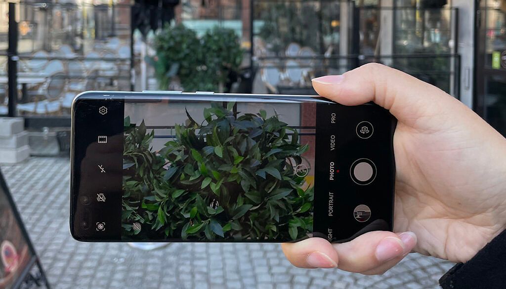 Person capturing an image of a plant on a smartphone using Imint's Vidhance Photo Zoom Stabilization solution