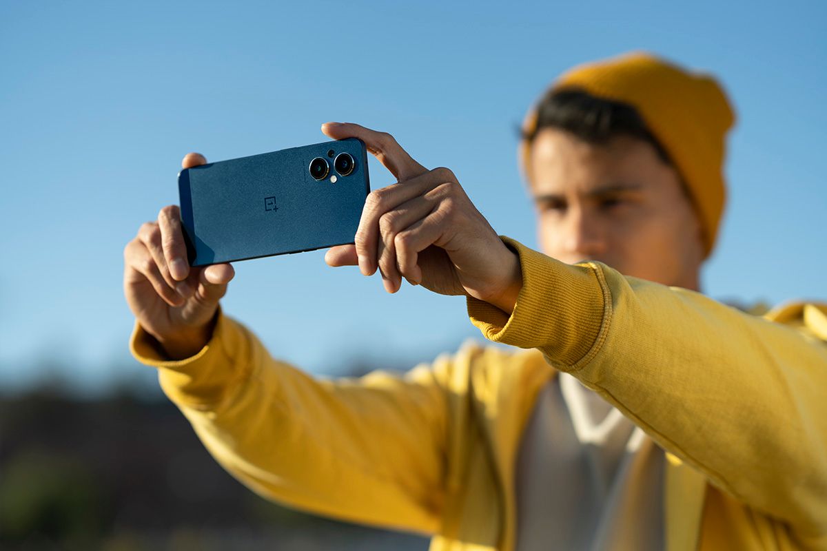 Person in yellow sweatshirt capturing a photo with the OnePlus Nord N20 5G