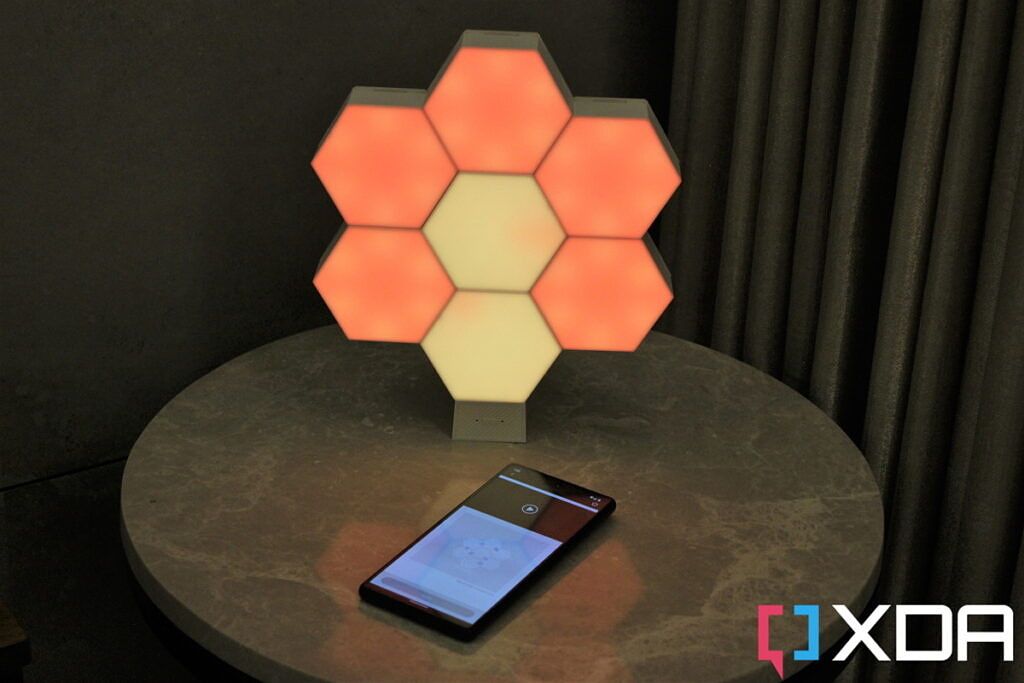 Cololight Hexagon Light Plus Kit assembled in a flower pattern with a phone kept in front of it