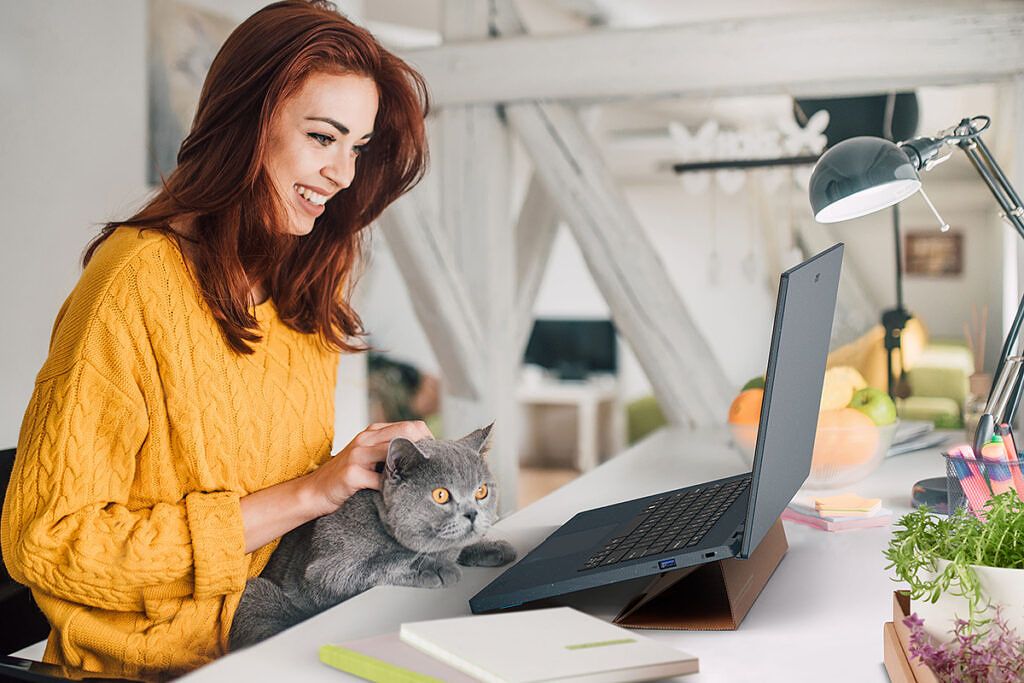 Woman and cat using laptop