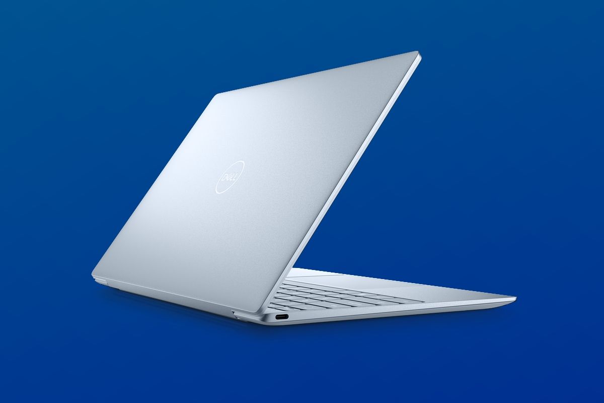 Angled rear view of the Dell XPS 13 with the lid partly open on a dark blue gradient background