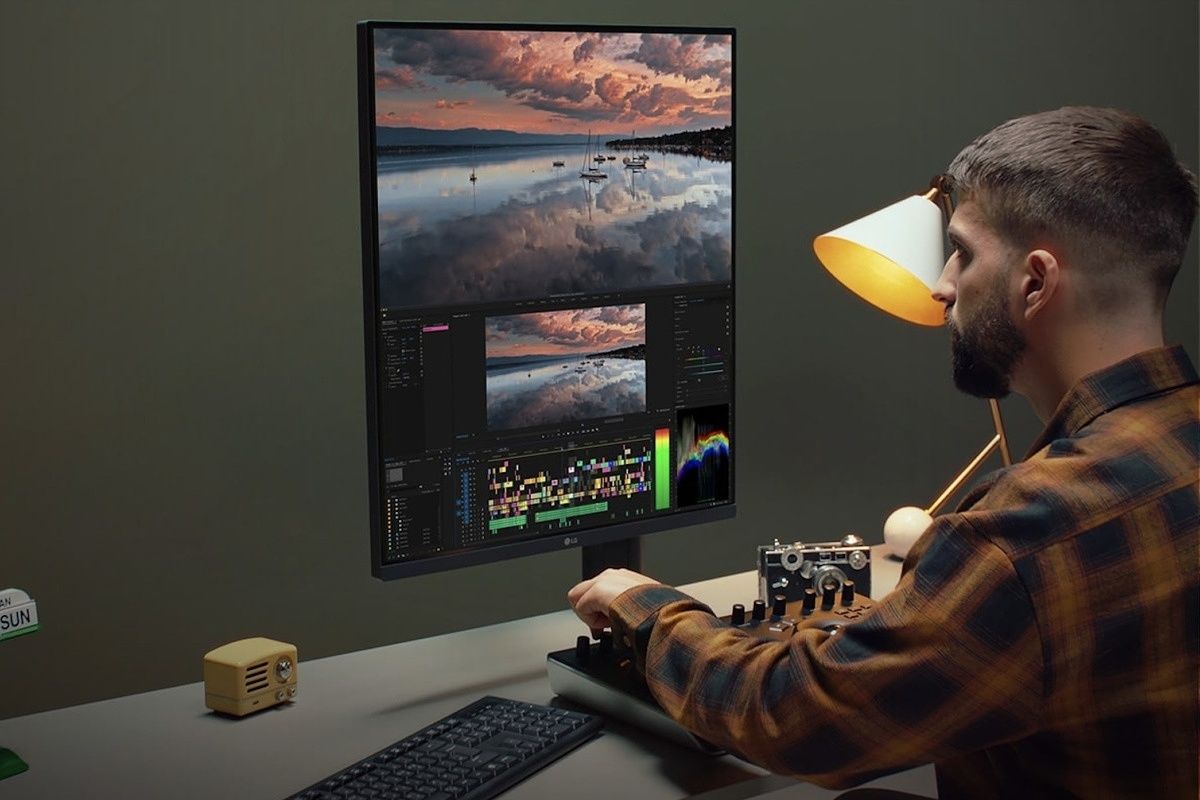 A man sitting in front of the LG DUalUp Monitor and using it to edit a video