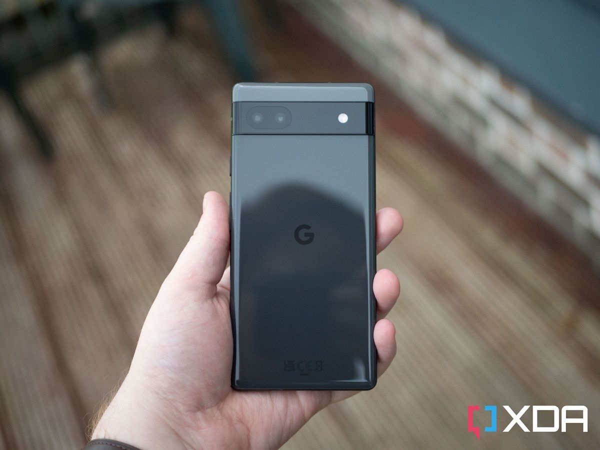 Google Pixel 6a in hand with blurred background.