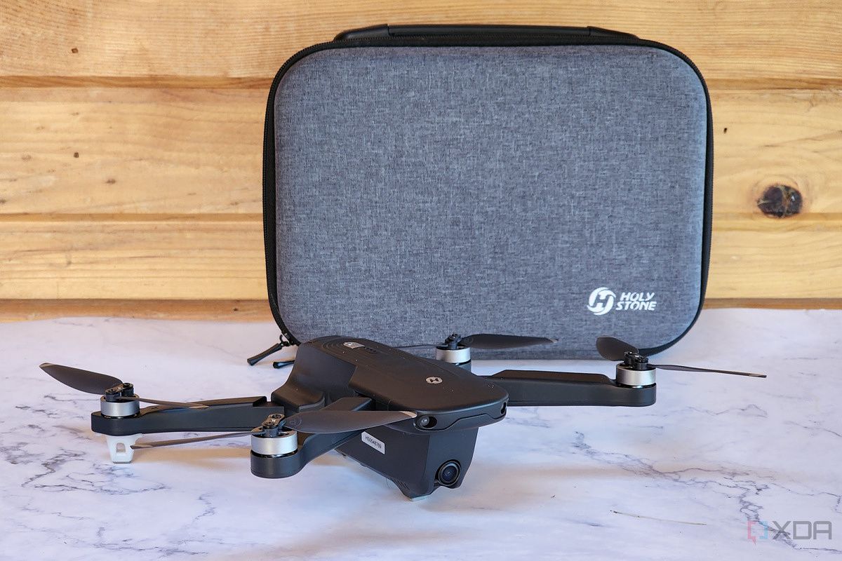 A drone sites on a table with a case behind it.