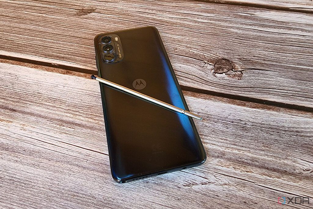 The Moto G Stylus 5G rests on a table with the stylus resting on the back of the phone.
