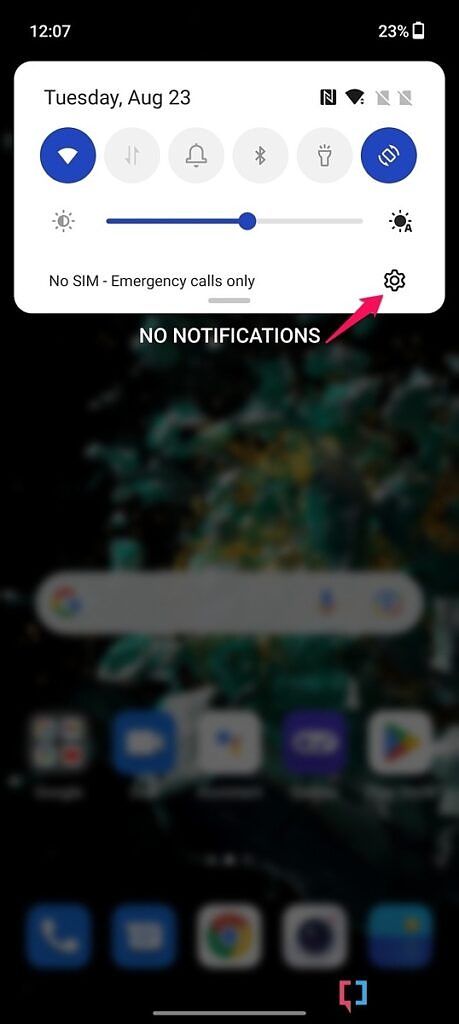 Screenshot of the notification shade on the OnePlus 10T with pink arrow pointing towards the Settings cog.
