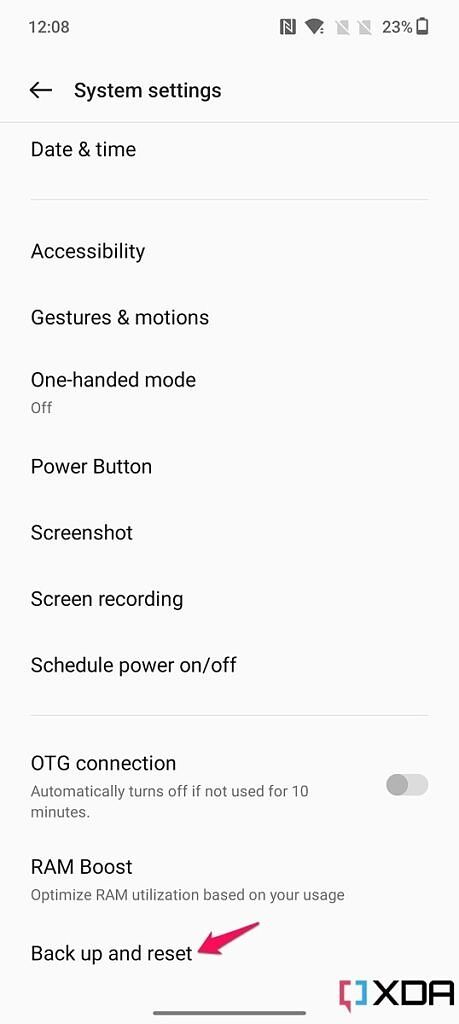 Screenshot of the System settings menu on the OnePlus 10T with pink arrow pointing at Back up and reset option.