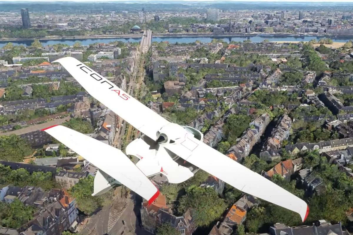 Screenshot of Microsoft Flight Simulator with white plane flying over Dusseldorf.
