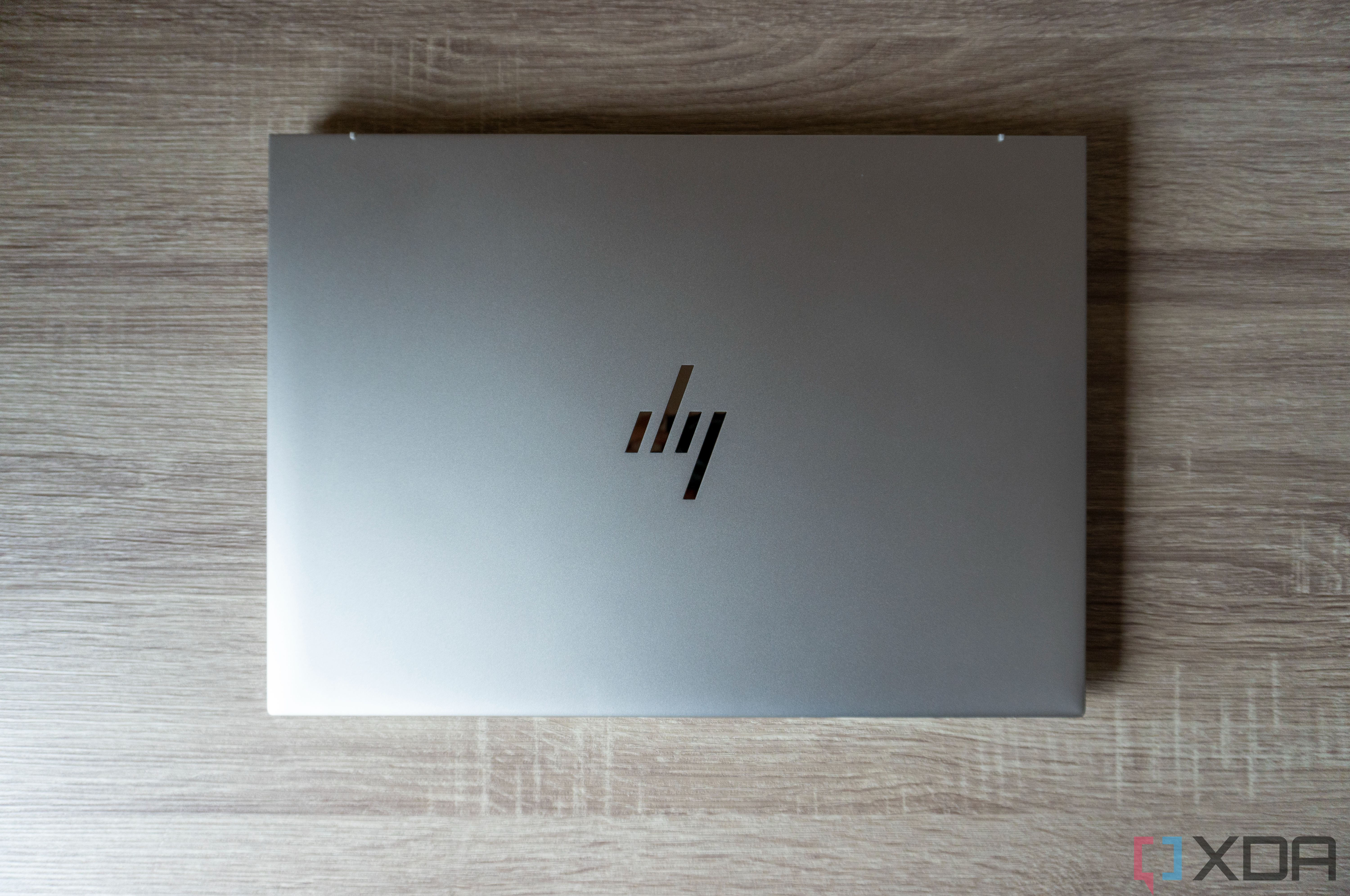 Vista aérea del HP EliteBook 865 G9 con la tapa cerrada sobre una mesa de madera