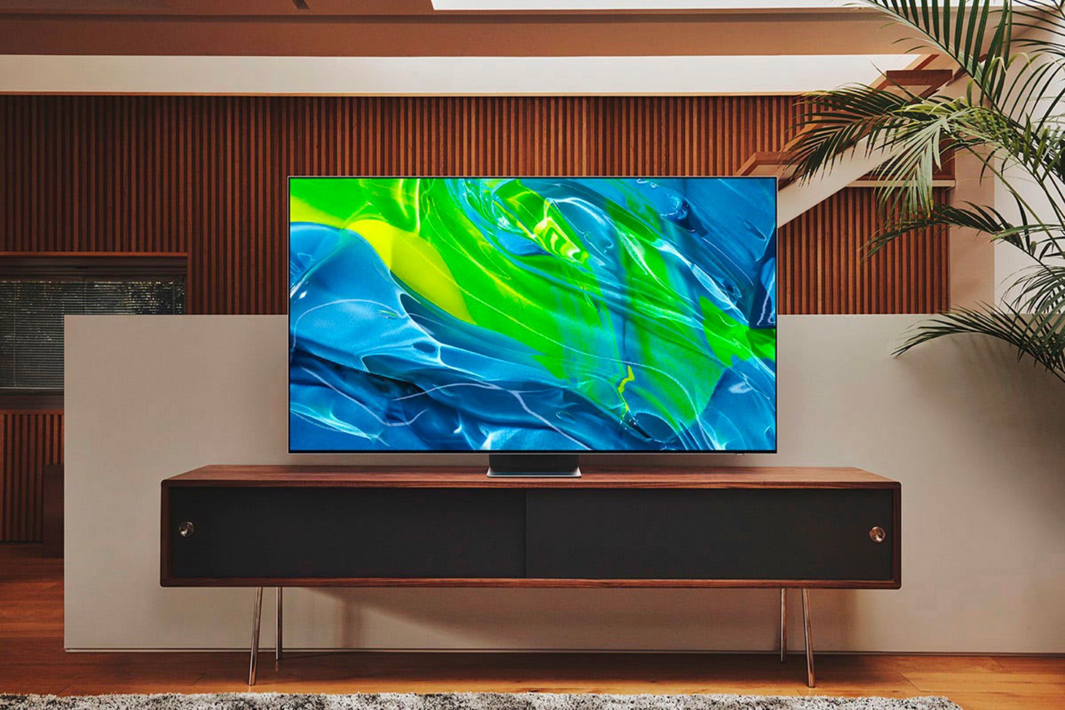 An image of Samsung S95B OLED 4K TV on a wodden cabinet.