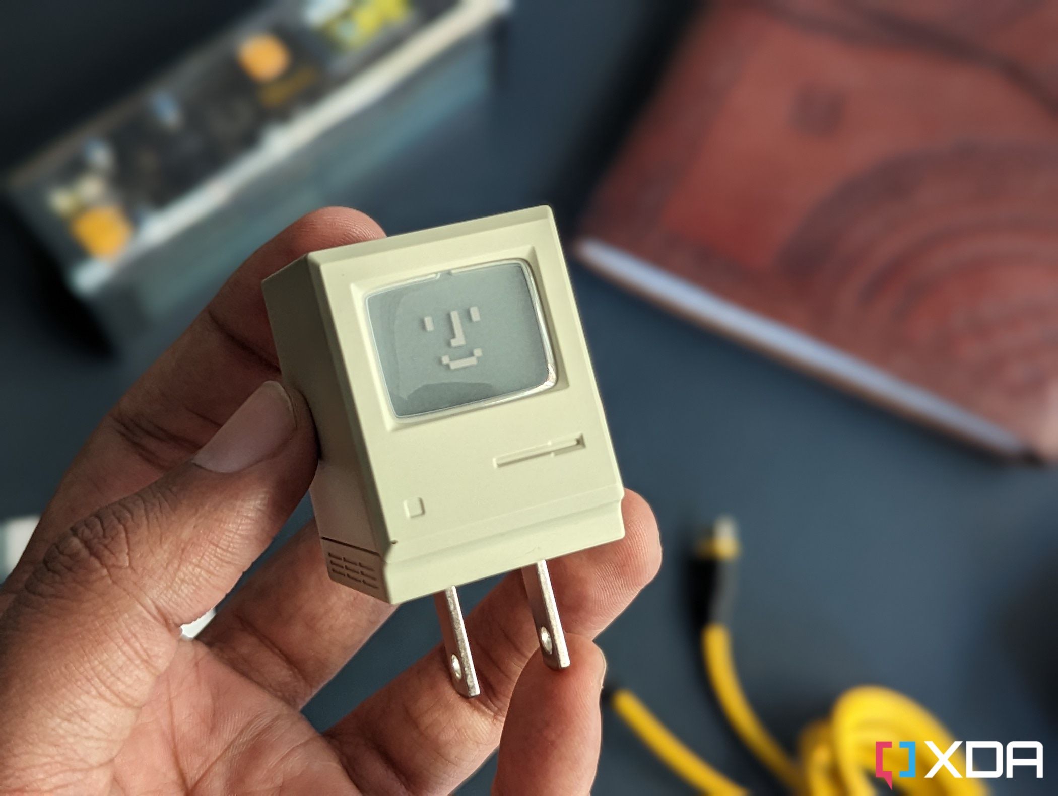 Una imagen de un cargador USB-C que se asemeja a la antigua computadora Macintosh de Apple en color beige.