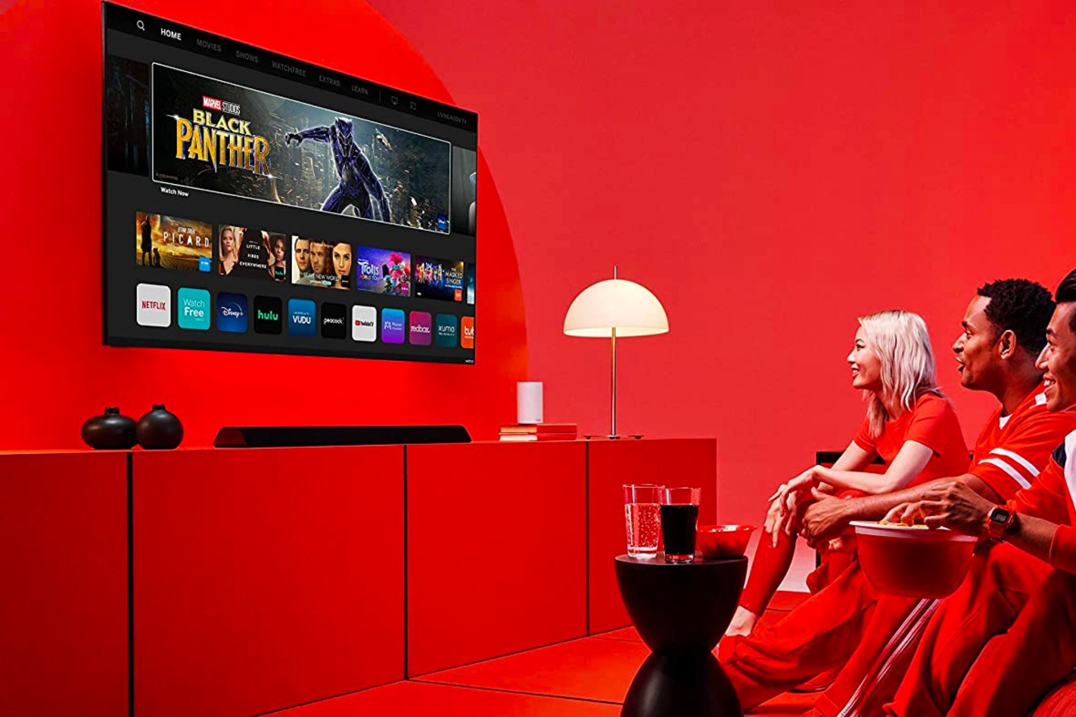 An image showing the Vizio M-series Quantum LED TV over a red-colored wall with matching red lighting in the room.