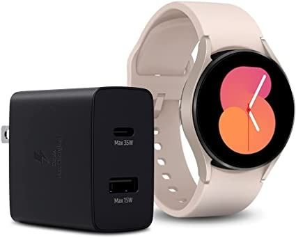 Samsung Galaxy Watch 5 en oro rosa con cargador de pared Duo de 35 W sobre fondo blanco.