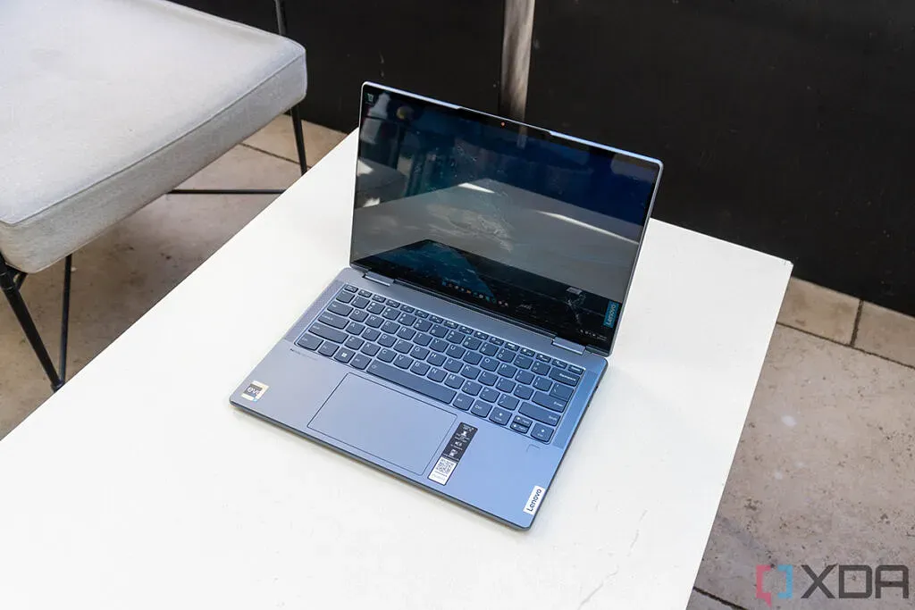 Yoga 7i on a desk with tiles in the background.