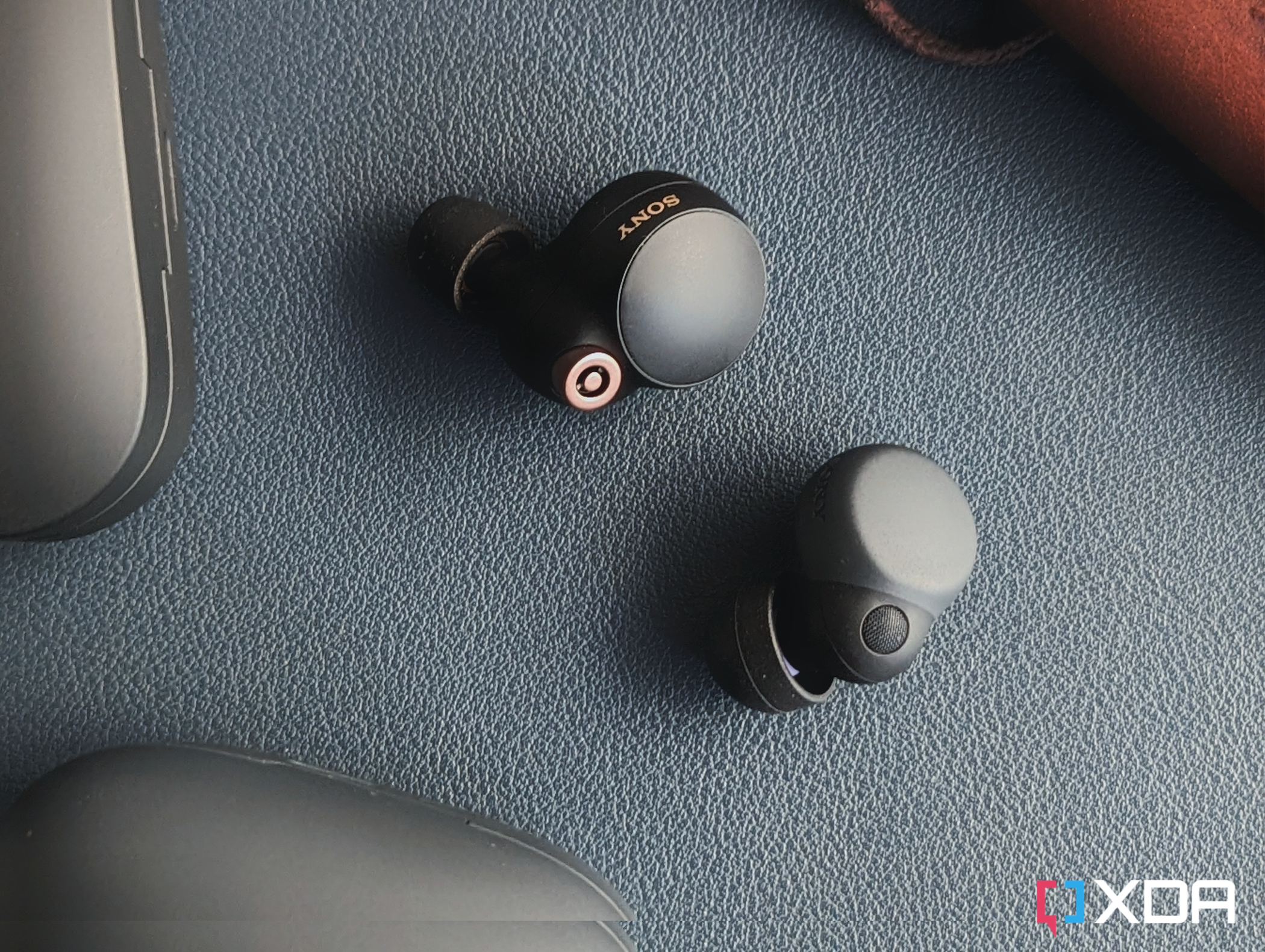 An image of the LinkBuds S and WF-1000XM4 earbuds next to each over over a leather mat.