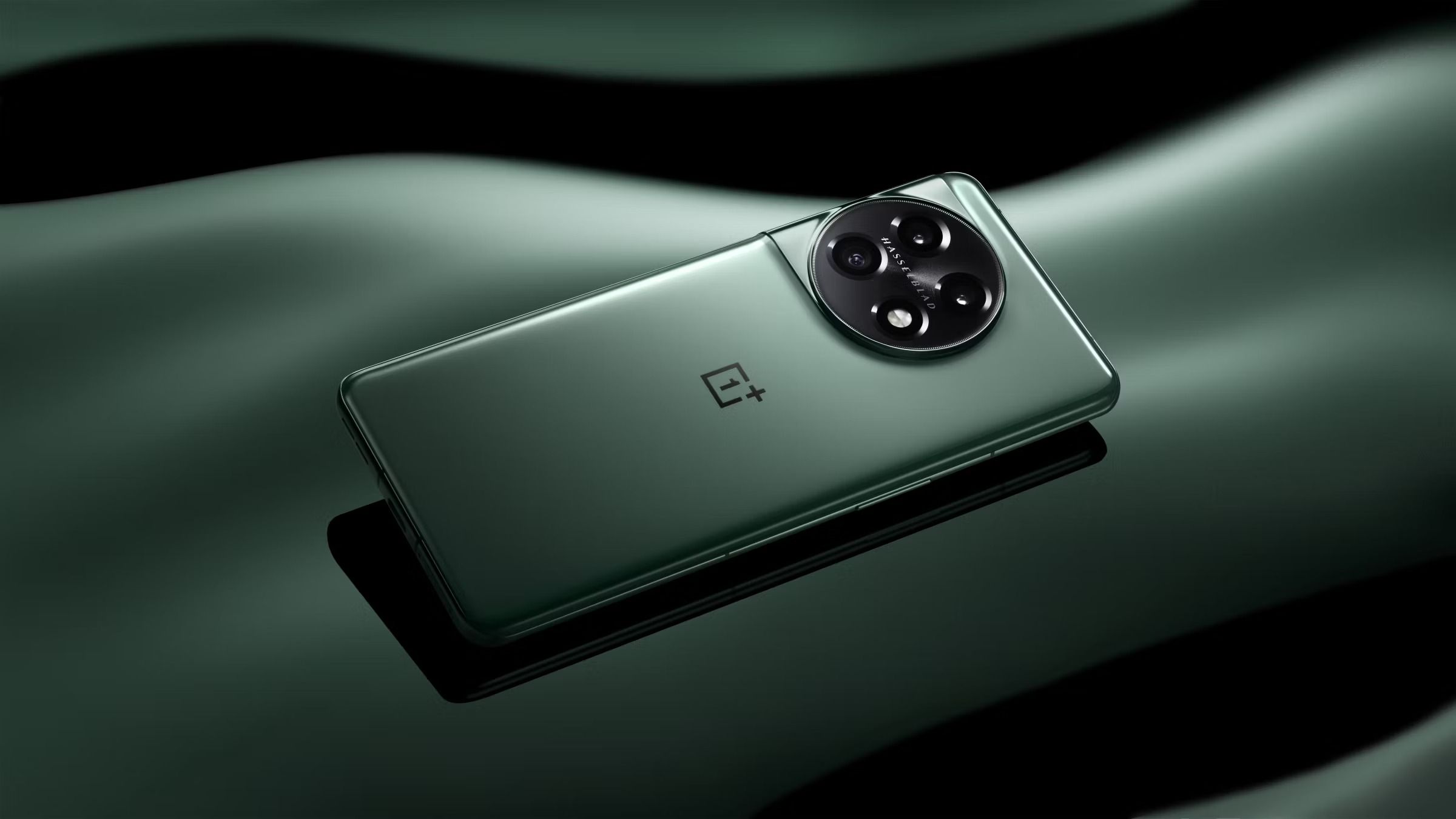 Green OnePlus 11 on stylized green background.