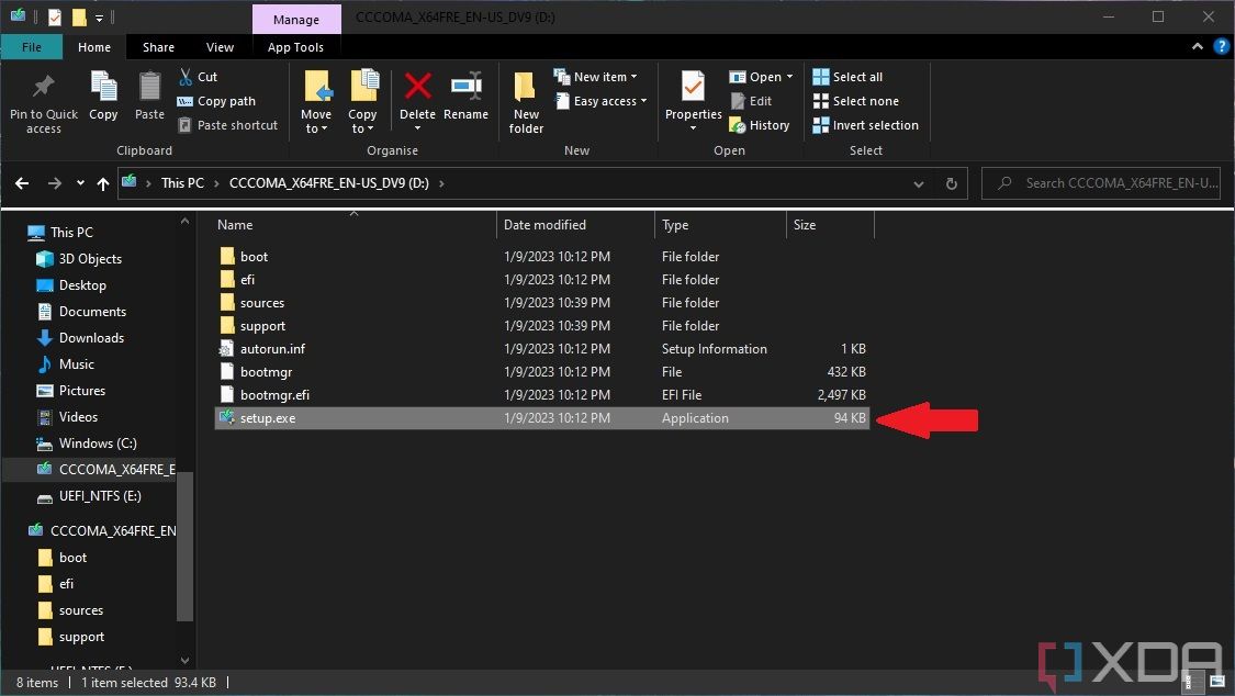 Screenshot of Windows 10 File Explorer showing files inside a USB drive containing Windows 11 installation files. The setup file is selected and highlighted by a red arrow