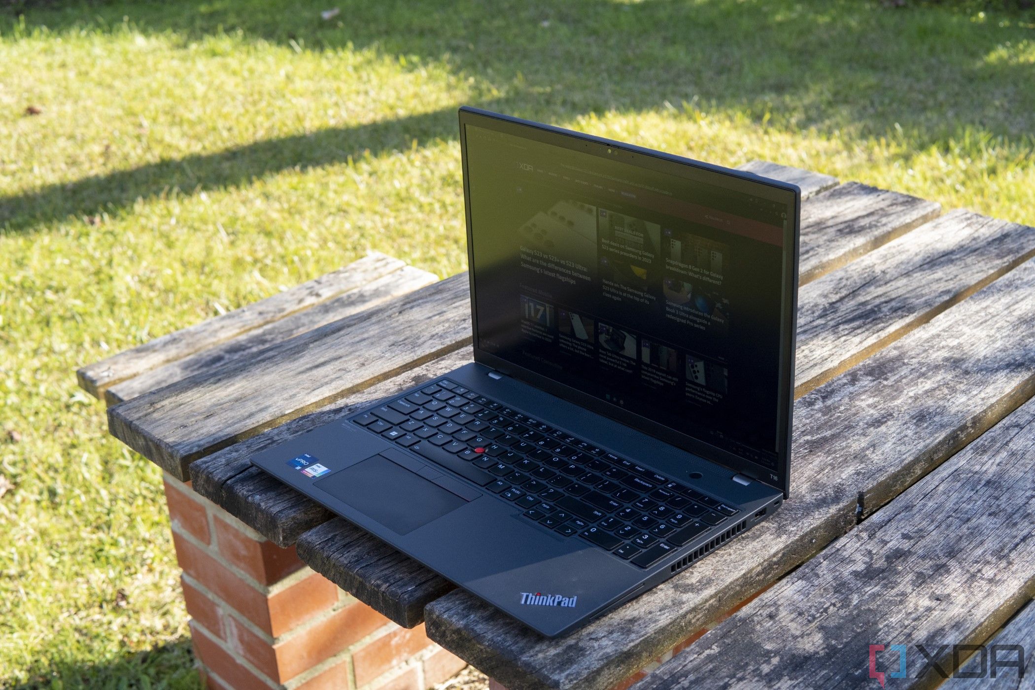 Angled front view of the Lenovo ThinkPad T16 on a wooden table facing left