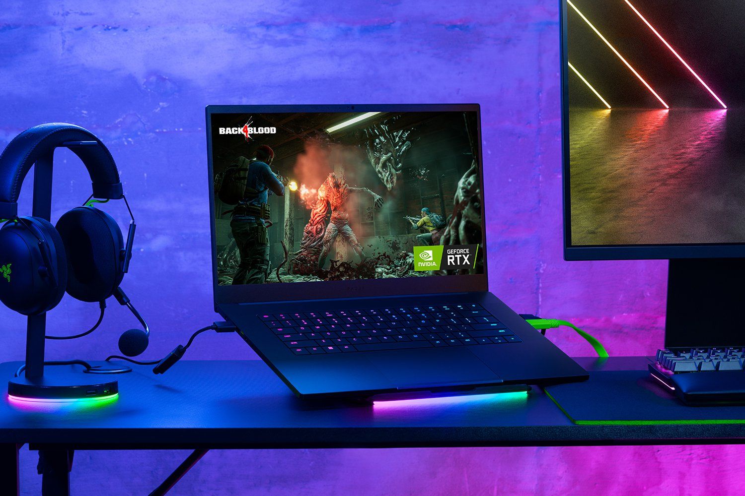 Angled view of a Razer Blade 15 2023 laptop on a desk next to PC peripherals