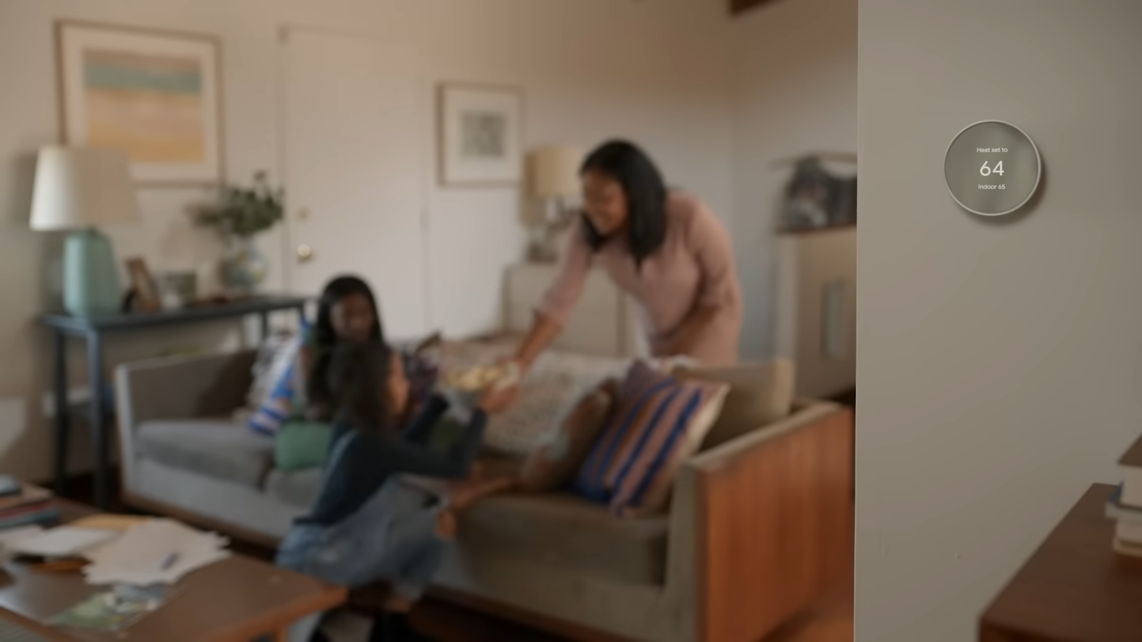 Google Nest Thermostat in a living room with a family staying comfortable and cool at 64 degrees